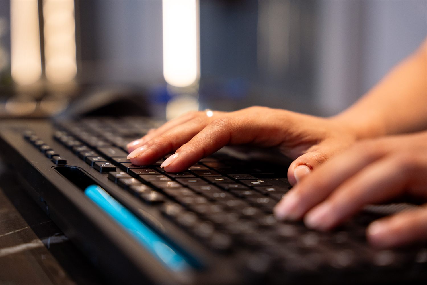 Hände auf einer Tastatur am Empfangstresen